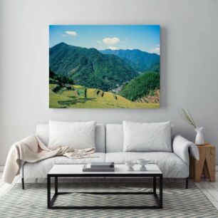 Πίνακας, μια καταπράσινη κοιλάδα που περιβάλλεται από βουνά κάτω από τον γαλάζιο ουρανό