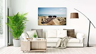 Πίνακας, ένα ζευγάρι γυαλιά ηλίου που κάθεται πάνω από μια αμμώδη παραλία