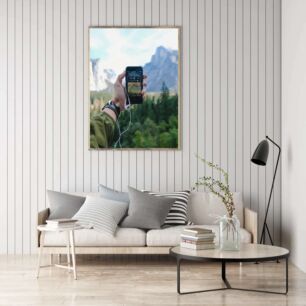 Πίνακας, ένα άτομο που κρατά ένα κινητό τηλέφωνο με ένα βουνό στο βάθος