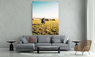 Πίνακας, ένα άτομο γονατιστό σε ένα χωράφι με αγελάδες στο βάθος