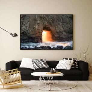 Πίνακας, ένα άτομο που οδηγεί μια σανίδα του σερφ μπροστά από μια σπηλιά