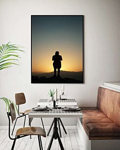 Πίνακας, ένα άτομο που στέκεται στην κορυφή ενός βουνού στο ηλιοβασίλεμα