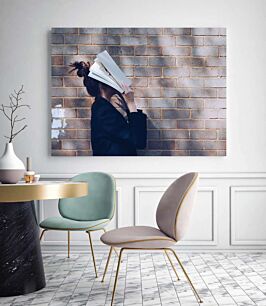 Πίνακας, μια γυναίκα που στέκεται μπροστά από έναν τοίχο από τούβλα διαβάζοντας ένα βιβλίο