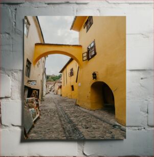 Πίνακας, Charming Cobblestone Street with Yellow Archway Καλαίσθητη Πλακόστρωτη Οδός με Κίτρινη Αψίδα